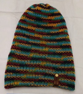 - Unisex Accessory - Material: 100% Acrylic Yarn / Custom Faux Leather Tag - Care: Hand Wash, Cold Water, Dry Flat - Construction: Reversible, Double Layered Knit Beanie (handmade) - Size: Adult (One Size) Stretchable - Color(s): Sky Blue and Multi-Colored Yarn - Item packed in clear resealable plastic storage bag